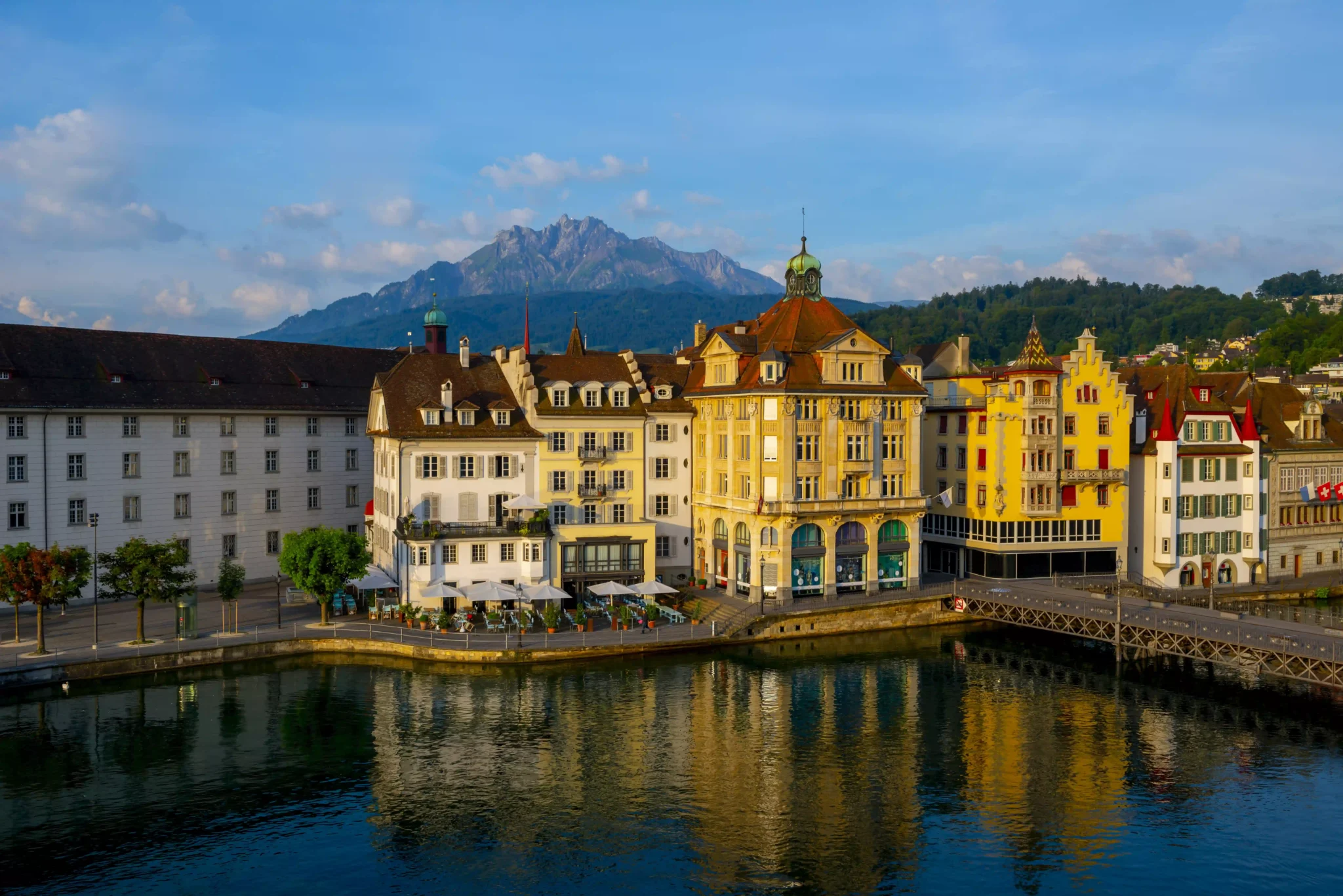 colorful-buildings-near-river-surrounded-by-mountains-lucerne-switzerland